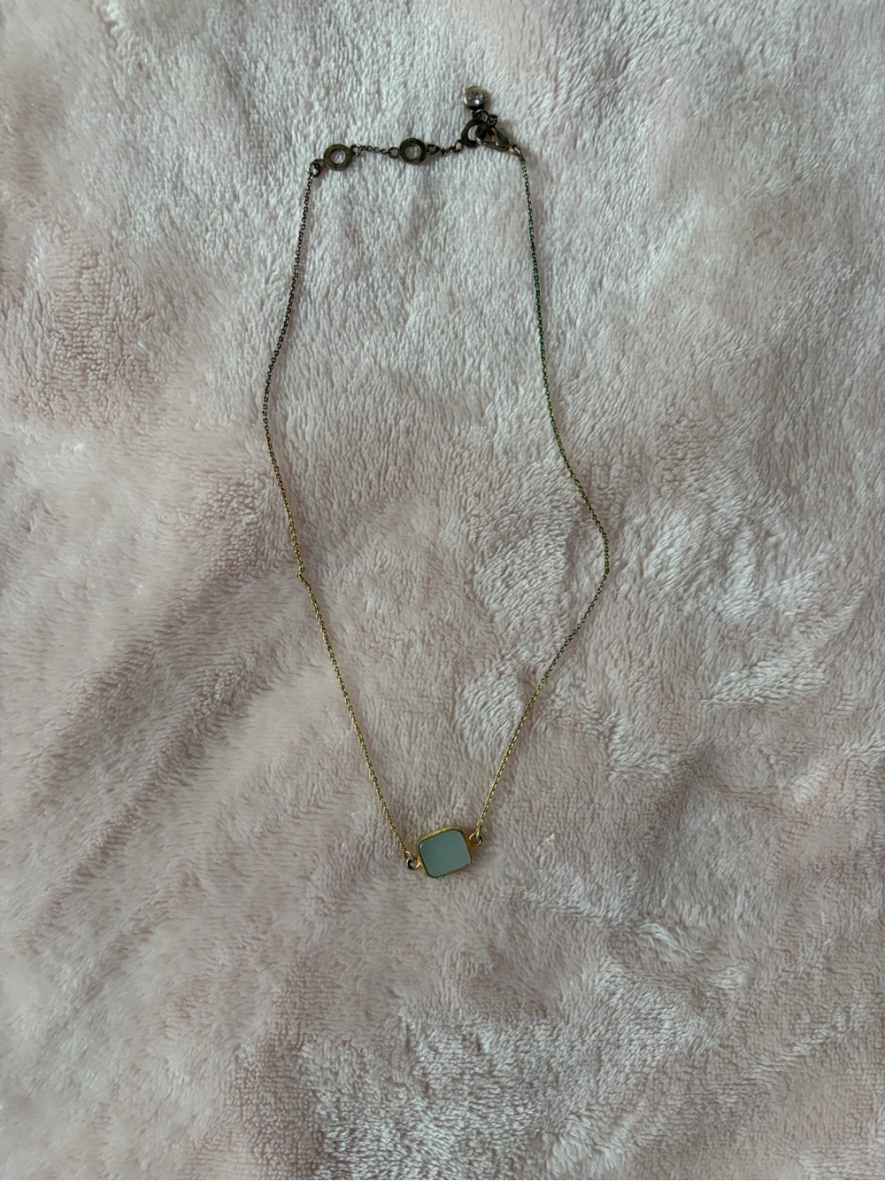 Short gold necklace with white stone